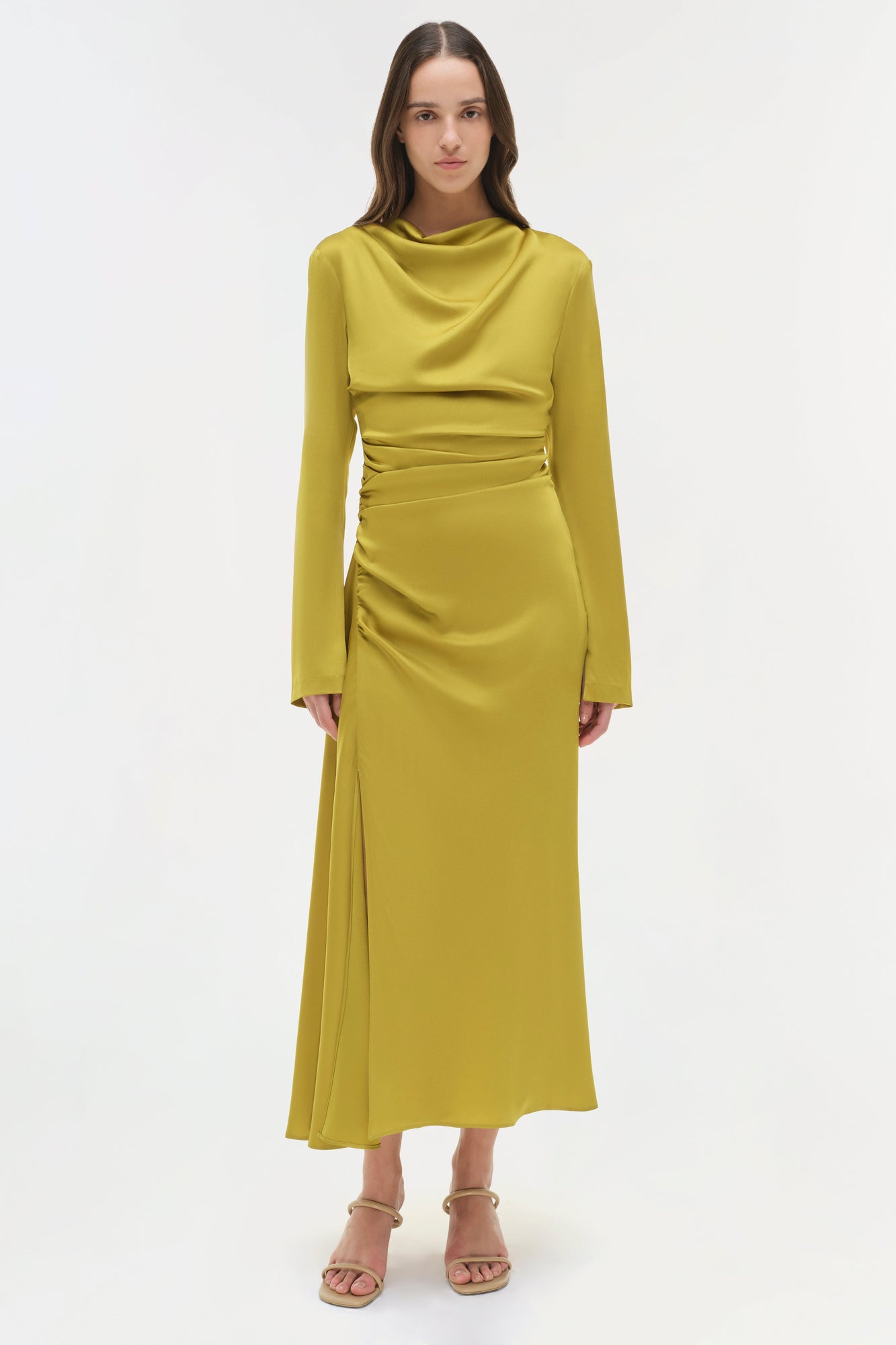 Chartreuse satin midi dress with long sleeves, ruched waist, and side slit, styled with nude platform sandals.