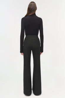 Black tailored trousers with flared legs and back pockets, worn with black turtleneck.