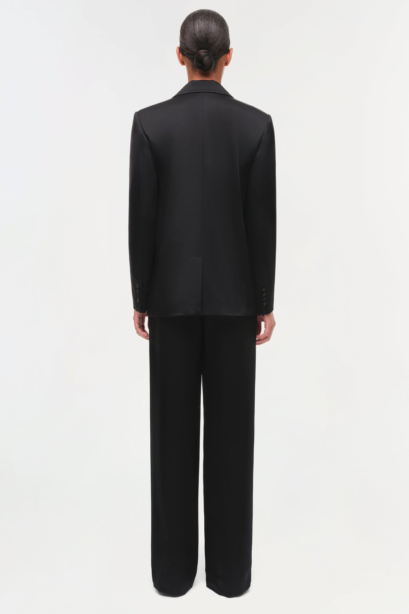 Person wearing a black suit viewing from the back