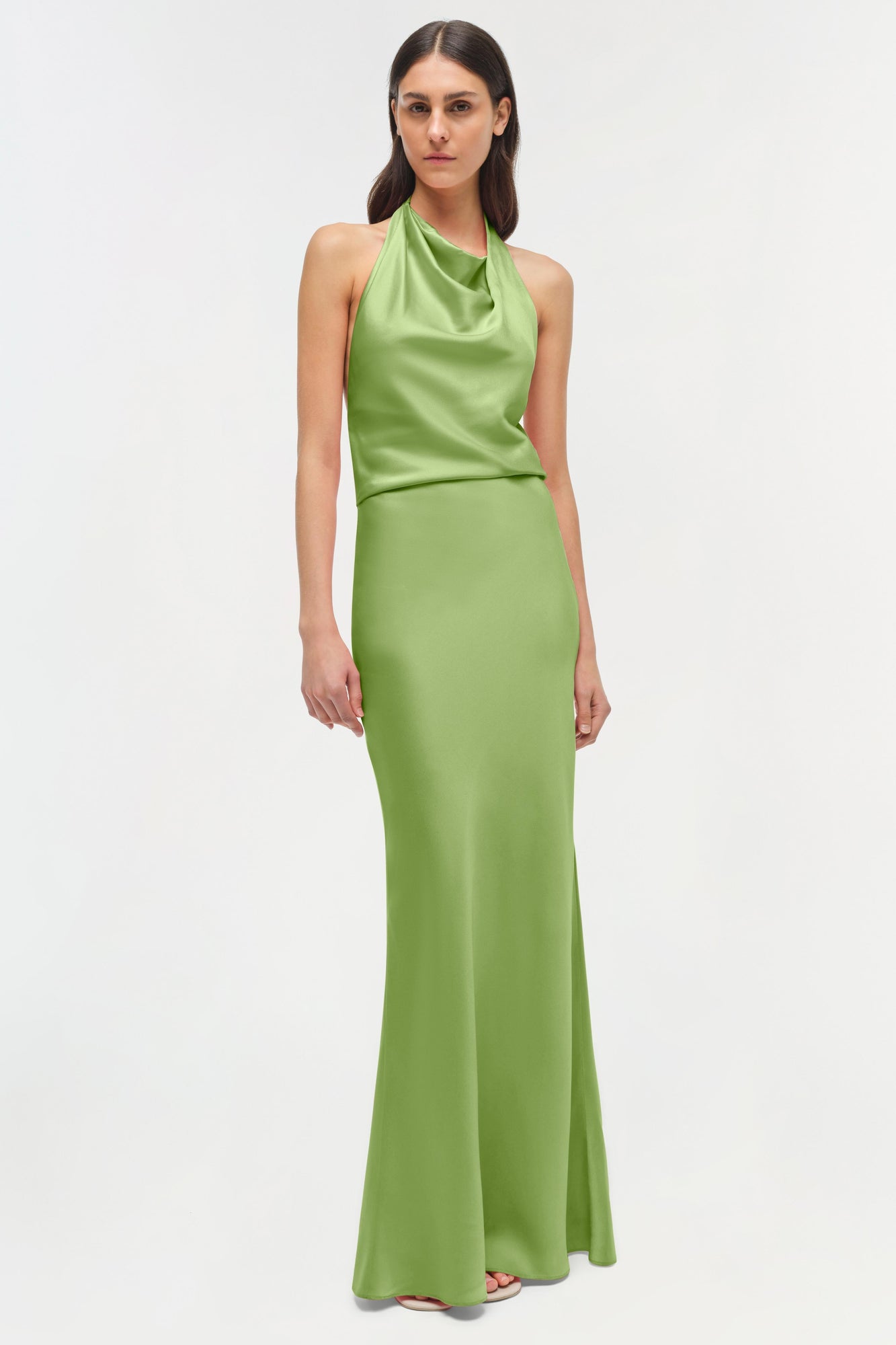 Woman wearing a lime green satin halter gown with a draped neckline and floor-length skirt.