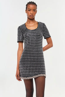 Black and white geometric patterned short-sleeve dress with contrasting trim at hemline.