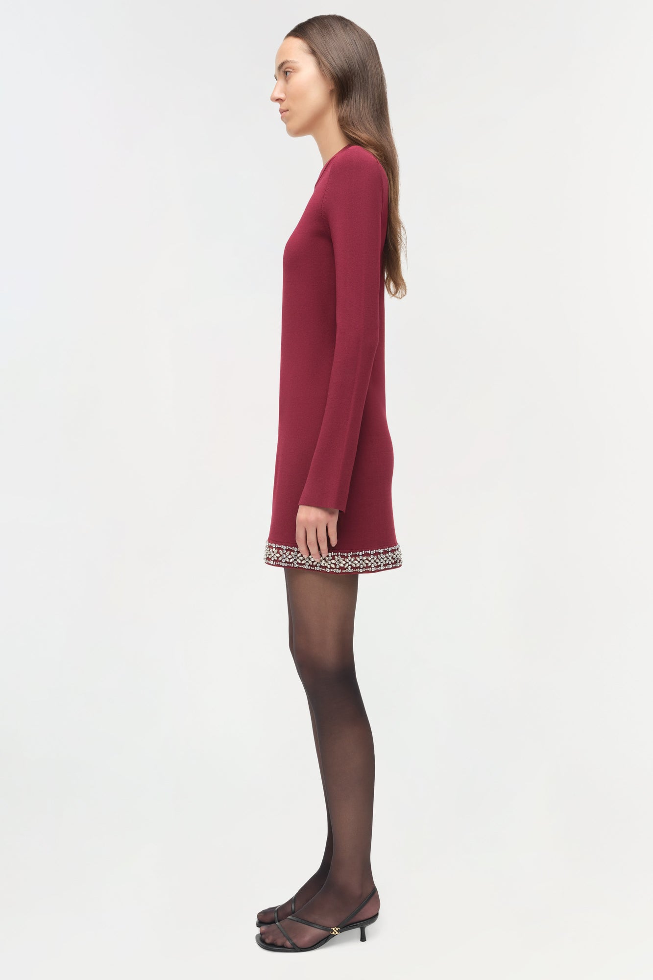 Burgundy knit mini dress with long sleeves and embellished trim at hem, styled with dark tights.