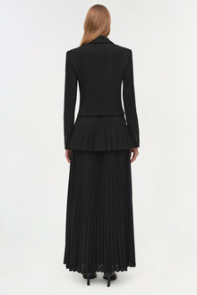 Black blazer midi dress with pleated skirt sections, shown from back on model with long brown hair.