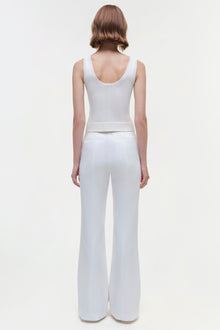 White sleeveless tank top with scoop neckline, shown from back on model wearing matching white flared pants.