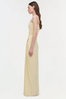Pale yellow strapless floor-length gown with ruched bustier bodice and draped side detail.