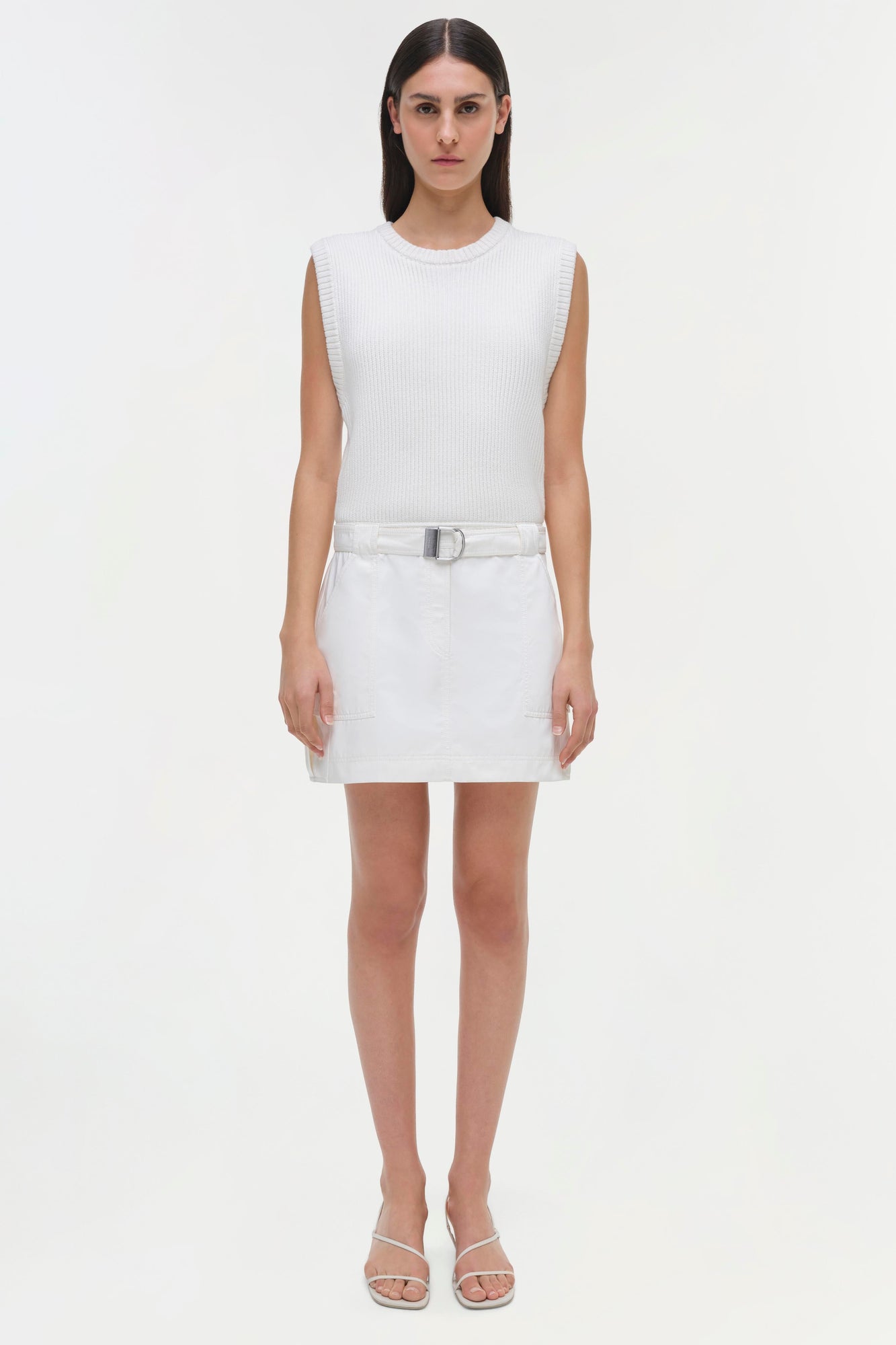 White sleeveless ribbed dress with matching belt and white sandals.