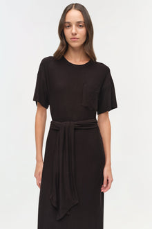 Black jersey t-shirt dress with short sleeves, chest pocket, and tie waist detail at center.