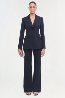 Navy blazer with notch lapels, button closure, and fitted waist, styled with matching trousers.