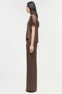 Brown satin t-shirt with short sleeves and draped front panel worn by model shown from side profile.