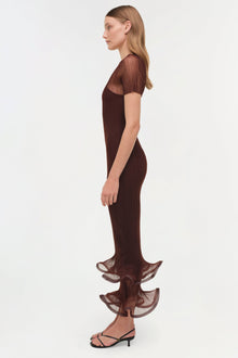 Woman wearing a burgundy plisse midi dress with sheer short sleeves and tiered ruffled hem, shown from the side.