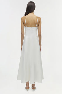 White sleeveless midi dress with thin straps and open back, shown from behind on model.