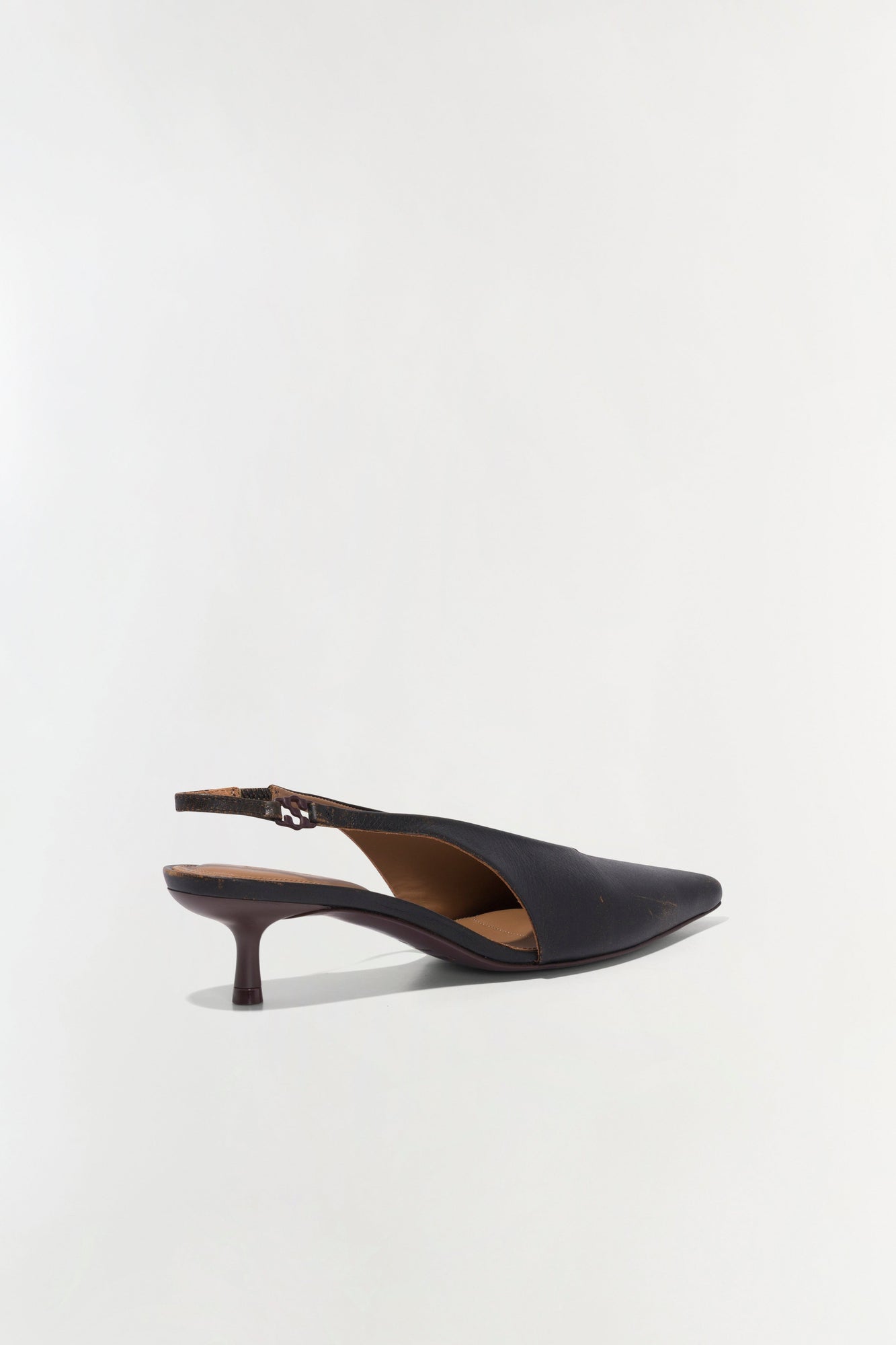 Black leather slingback heel with pointed toe and thin kitten heel, shown from the side profile.