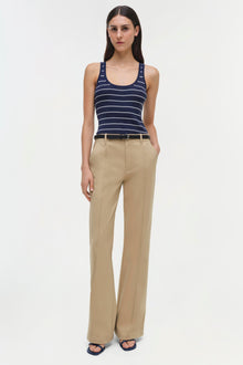 Beige wide-leg trouser with center crease seam, worn with navy striped tank top and belt.