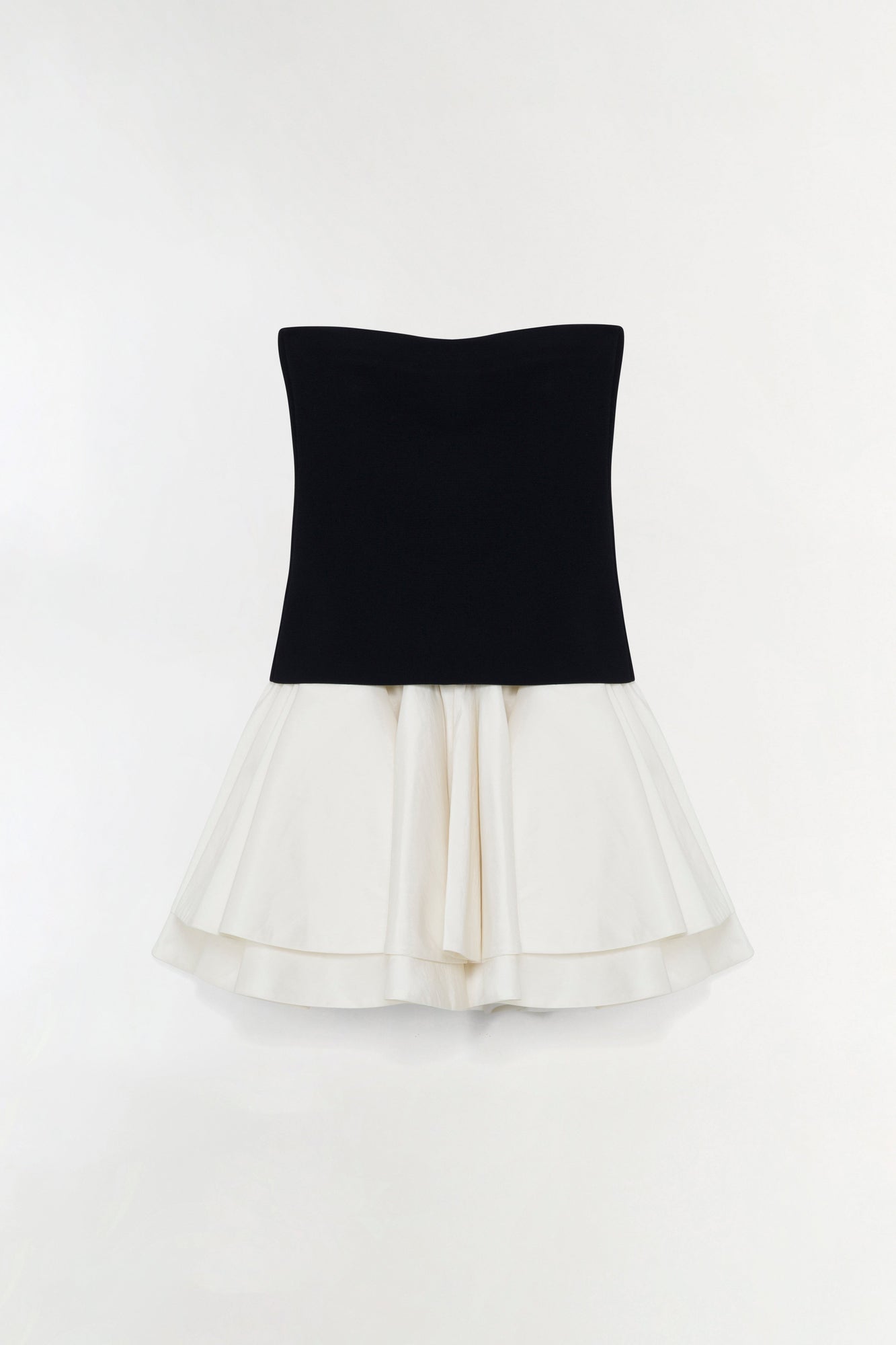 Black knit strapless top with cream taffeta skirt featuring layered ruffled hem.