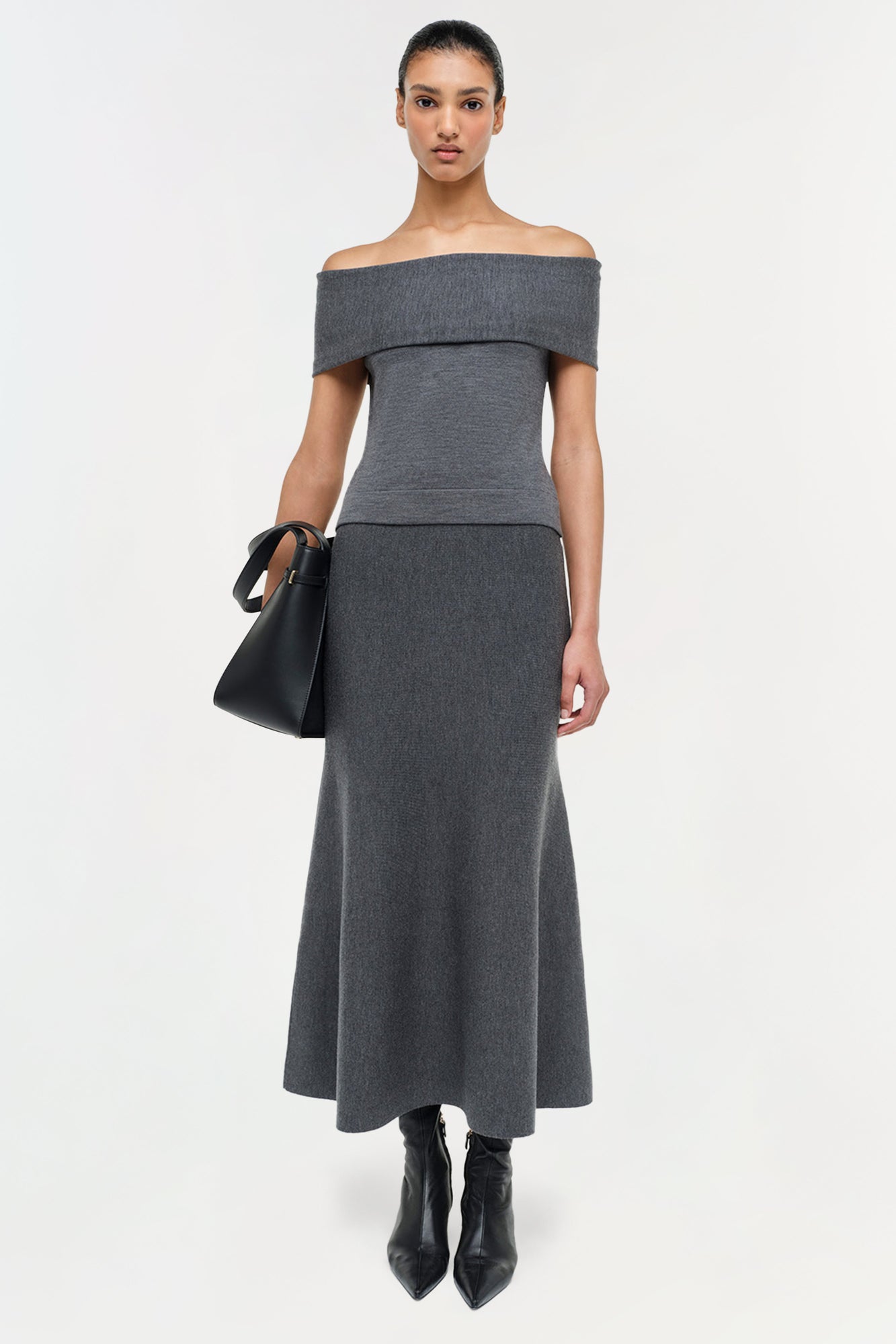 Gray wool A-line skirt with fitted waistband, worn with off-shoulder top and black boots.