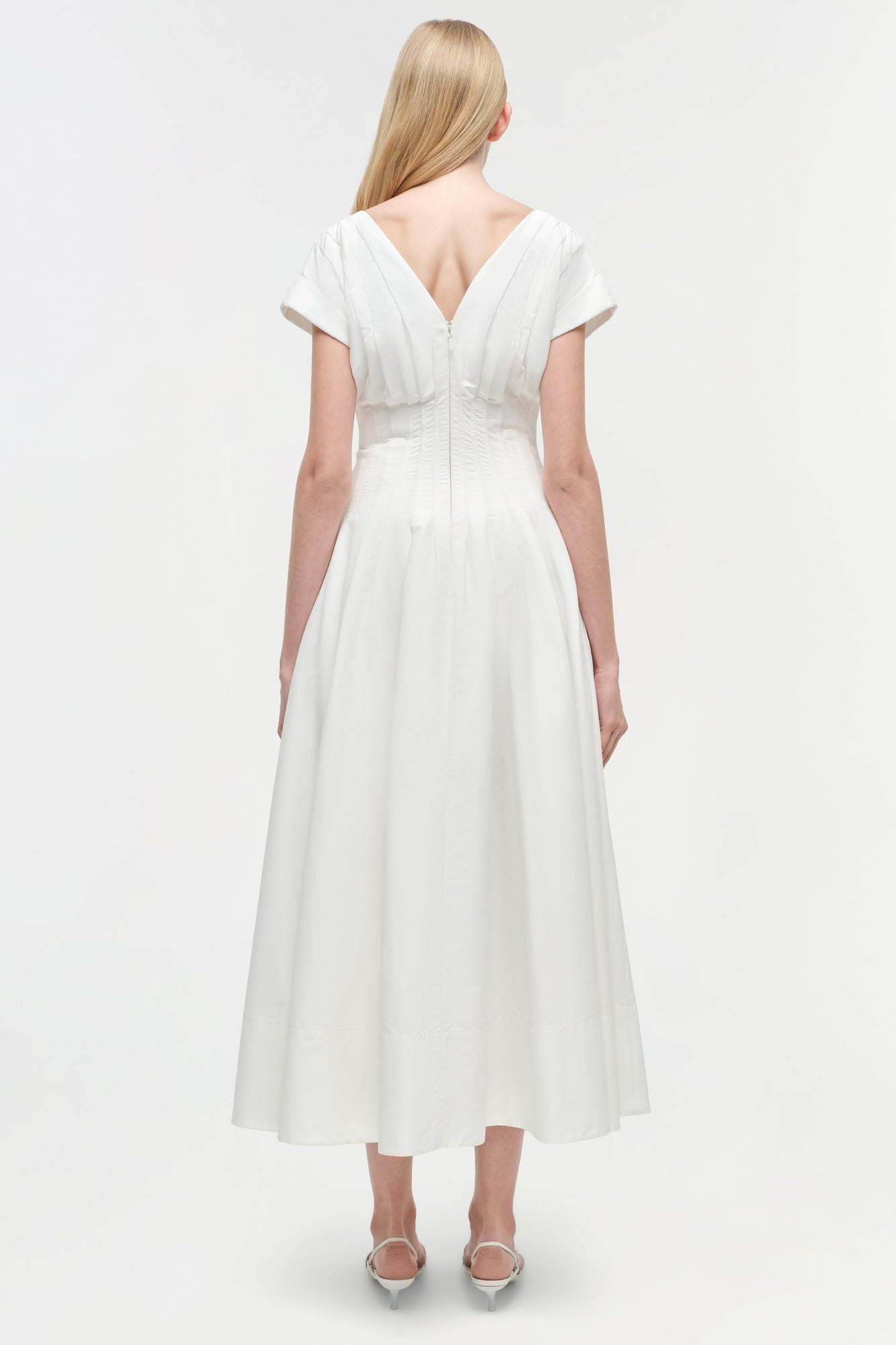 White cotton midi dress with short sleeves, V-neckline, and gathered waist detail, shown from back view.