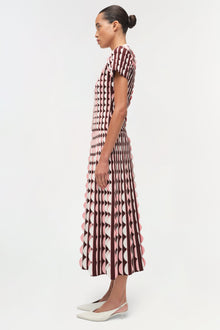 Burgundy and cream knit midi skirt with geometric pattern and scalloped hem edges, shown on model from side view.