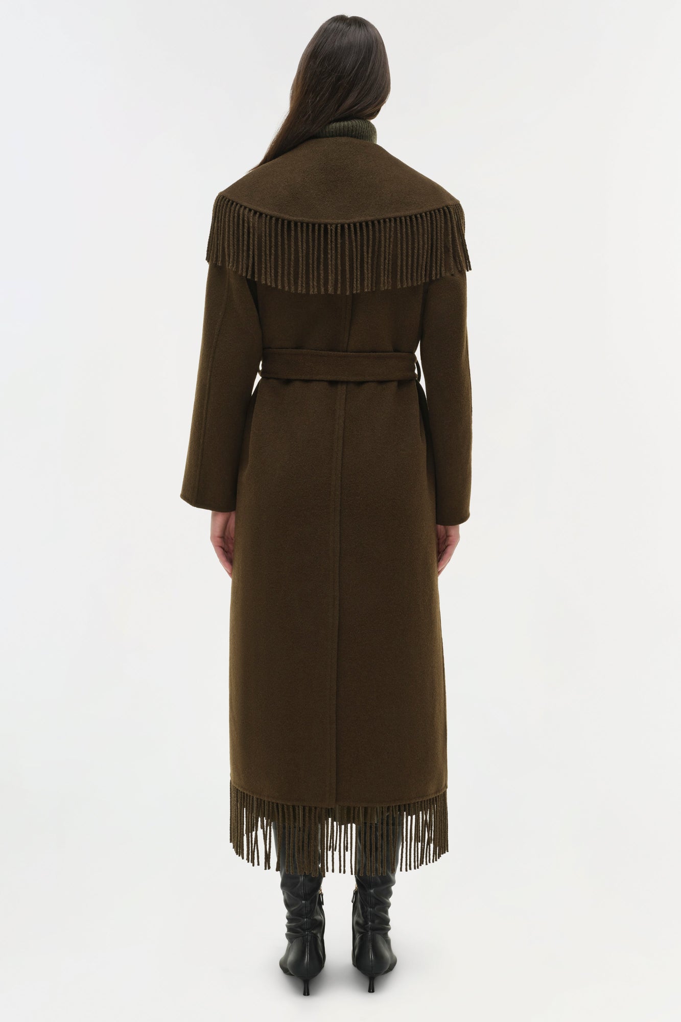 Olive green wool coat with fringe trim on shoulders and hem, belted waist, and long sleeves, shown from back.