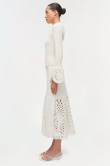 Cream knit top with eyelet embroidered cuff and matching skirt with cutout details.