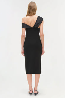 Woman wearing black off-shoulder midi dress with draped neckline, shown from back view.