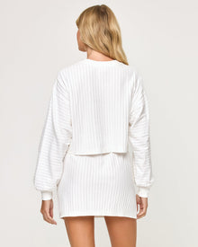 Back view of model wearing the Half Court Pullover in white with matching white Half Court Skirt.