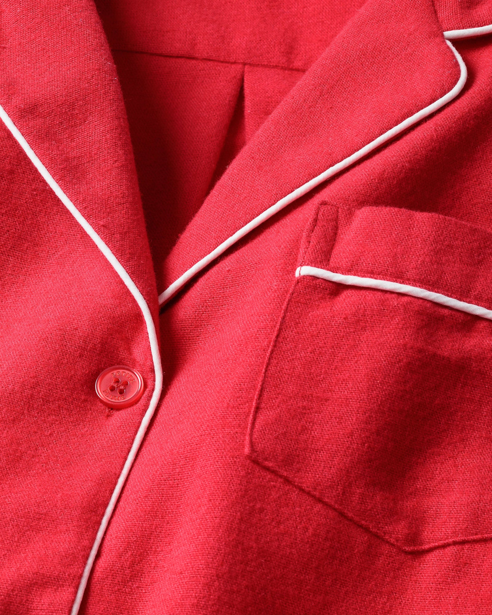 Close-up of Petite Plumes luxury Womens Flannel Nightshirt in red, crafted from soft, 100% cotton. It features white piping along the collar, a chest pocket, and a matching red button on the right side.