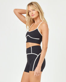 Side view of model wearing the Revel Top in black-cream with matching black-cream Revel Short.