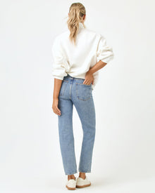 Back full-length studio view of the Crush Sweatshirt in cream, a cream quarter-zip pullover sweatshirt, styled with blue jeans and white sneakers.