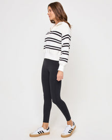 Side view of the LSPACE Ultra Stripe Sweater in black-white on a model, showing the profile and ribbed texture of the black and white striped sweater.