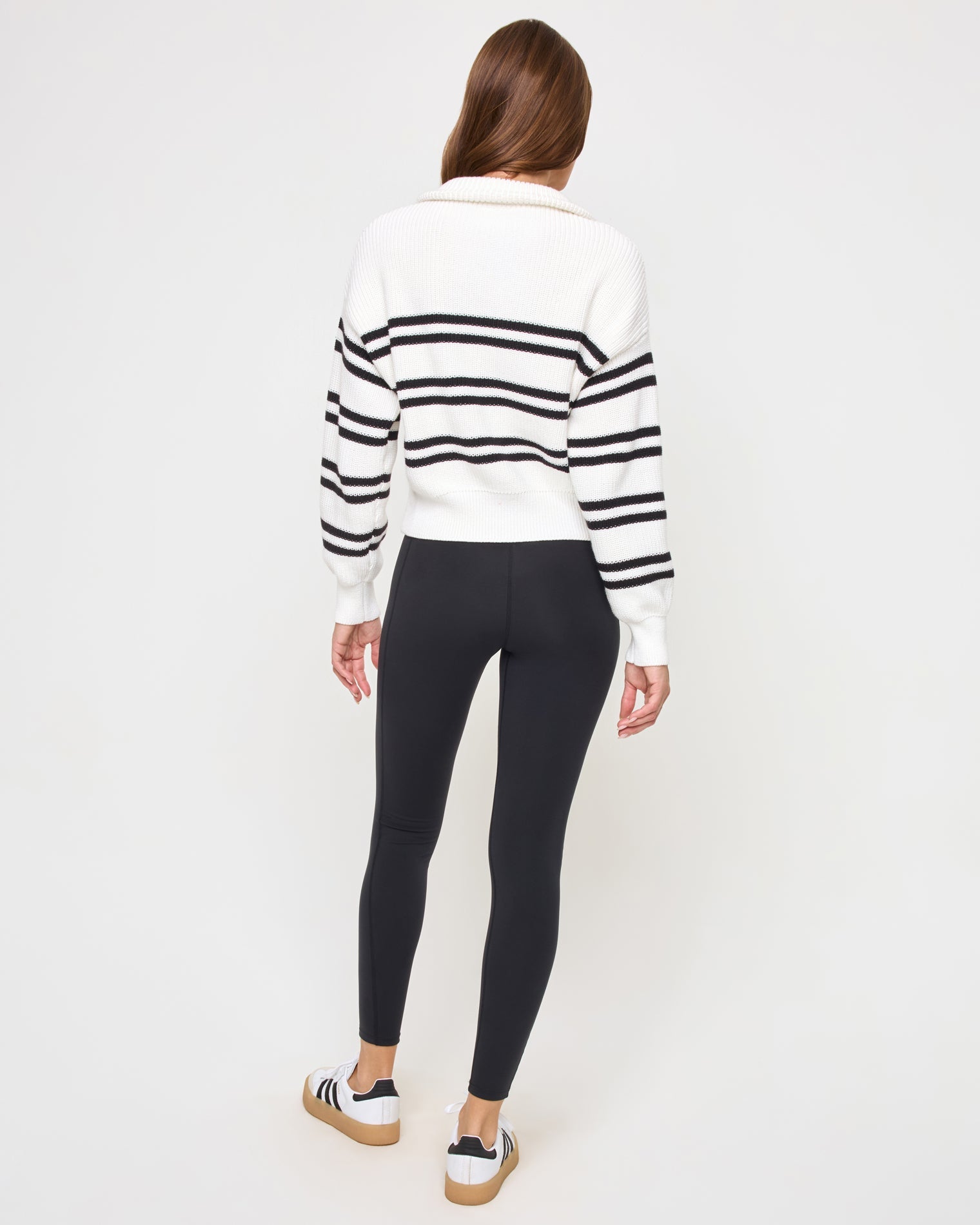 Back view of the LSPACE Ultra Stripe Sweater in black-white on a model, showing the back of the ribbed sweater with bold black and white horizontal stripes.