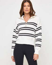 Close-up front view of the LSPACE Ultra Stripe Sweater in black-white on a model, showing the bold black and white horizontal stripe pattern and half-zip neckline detail.