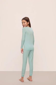 Model is wearing Kids Tencel Modal Unisex Long Pj Set in Canal Blue/Ivory