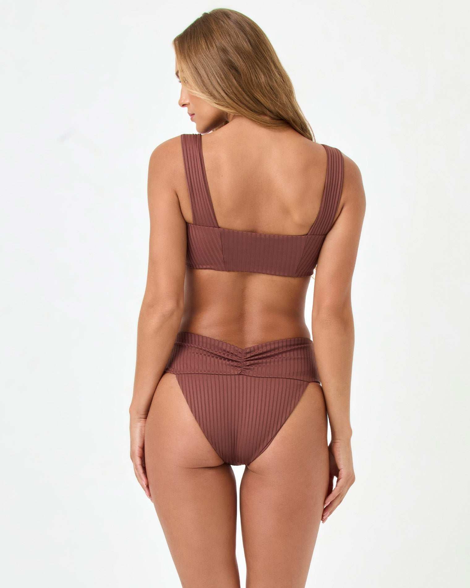 back view of woman wearing a brown bikini on a white background