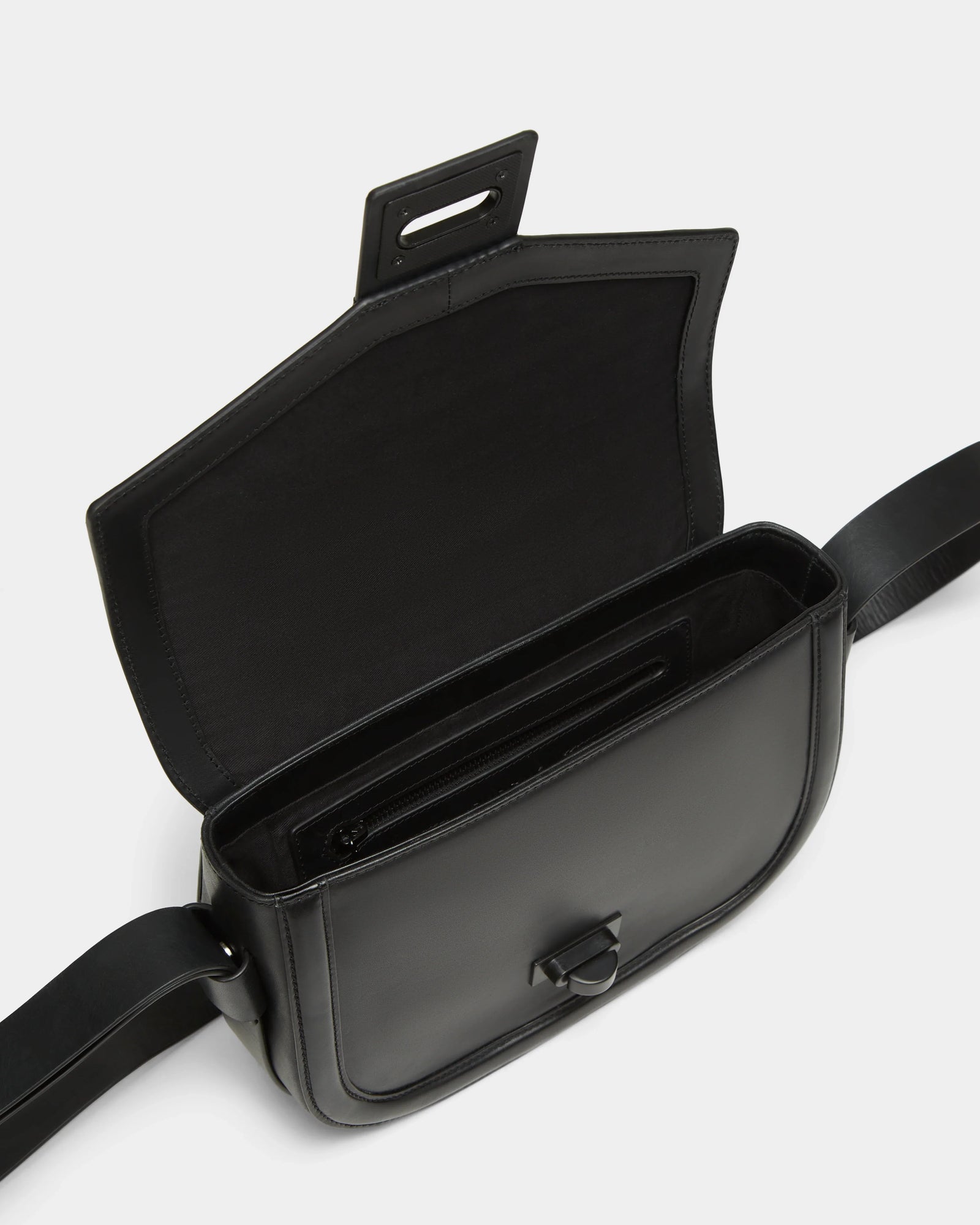 The Rudsak ALORA - 8324506 Black crossbody bag features premium leather, a wide adjustable strap, minimalist design, and an open flap revealing a spacious interior with an inner zippered pocket.