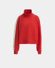 The Rudsak KELLIE - 8524615 Flame Red is a women’s mock neck top with long sleeves, ribbed cuffs, and white arm stripes in a relaxed fit, shown against a plain light background.