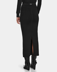 Wearing the Rudsak MONICA - 8524516 Black skirt, styled with black ankle boots, a person is shown from behind against a plain background.