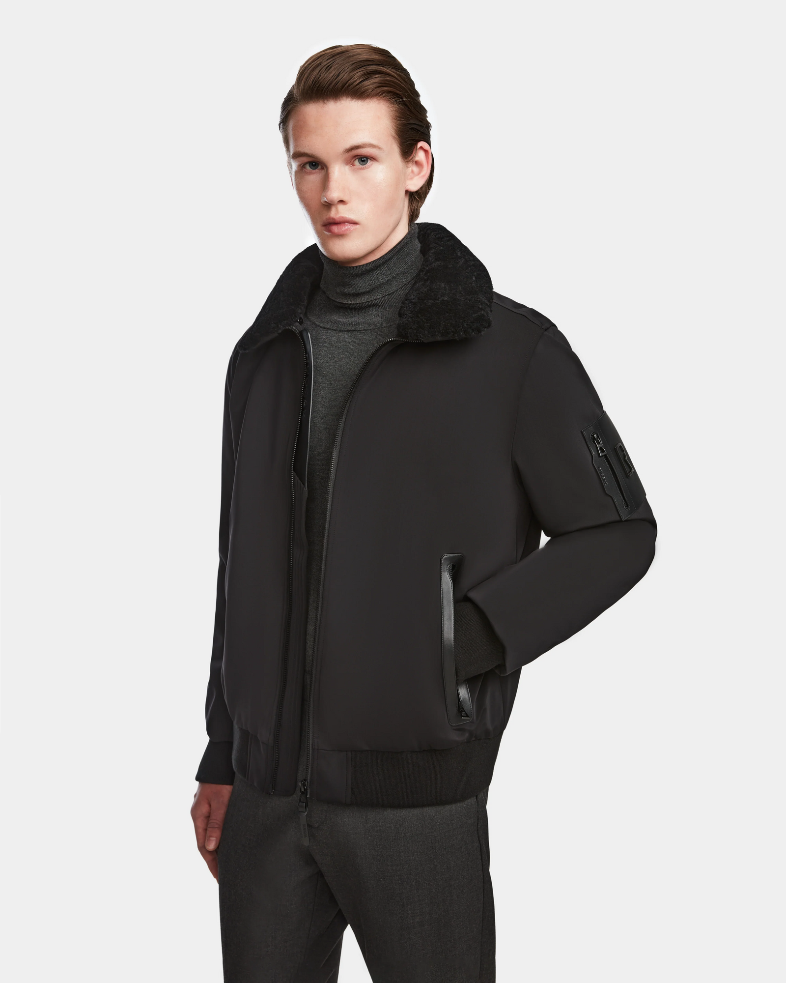 A man in the Rudsak REECE - 6124592 Black mens bomber jacket featuring a stylish shearling collar.