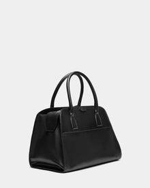 The YASMINA L - 8324516 Black by Rudsak is a black leather tote bag with two rounded handles and a structured rectangular, minimalistic design, shown against a plain light gray background.