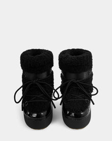 The KATHY Y - 1224500 Black winter boots by Rudsak feature a water-repellent, fuzzy textured upper, thick soles, and black laces, shown from the front against a white background.