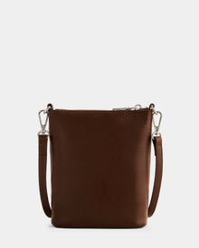 The Rudsak LILA - L325513 Mocha is a small rectangular women’s crossbody bag in brown pebbled leather, featuring a textured surface, adjustable strap with silver clasps, and silver zipper, shown on a white background.