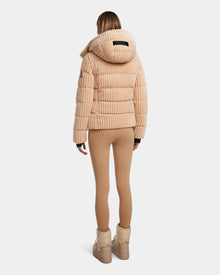 A person faces away, wearing the MIRRY FF - L124507 Iceland beige velvet corduroy puffer with hood by Rudsak, tan leggings, and beige boots against a plain white background.