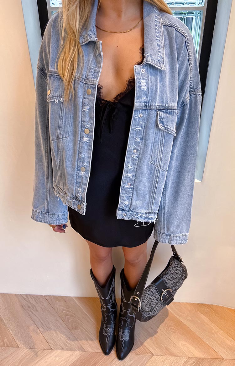 Front view of a light wash oversized denim jacket with dropped shoulders, buttoned chest pockets, and cuffs