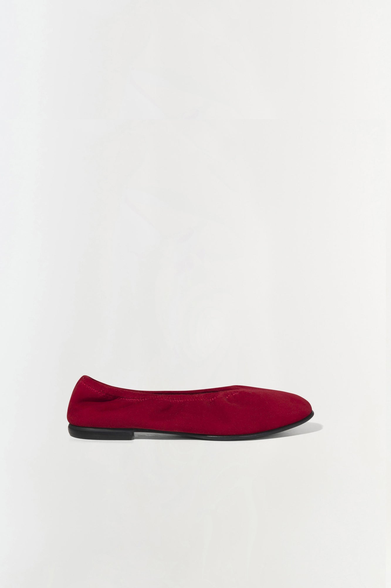 Burgundy suede ballet flat with black sole, shown in profile view.