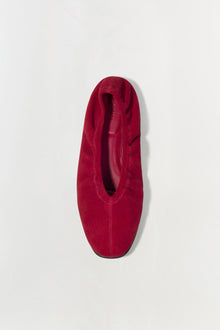Burgundy suede ballet flat shown from above with rounded toe and dark sole.