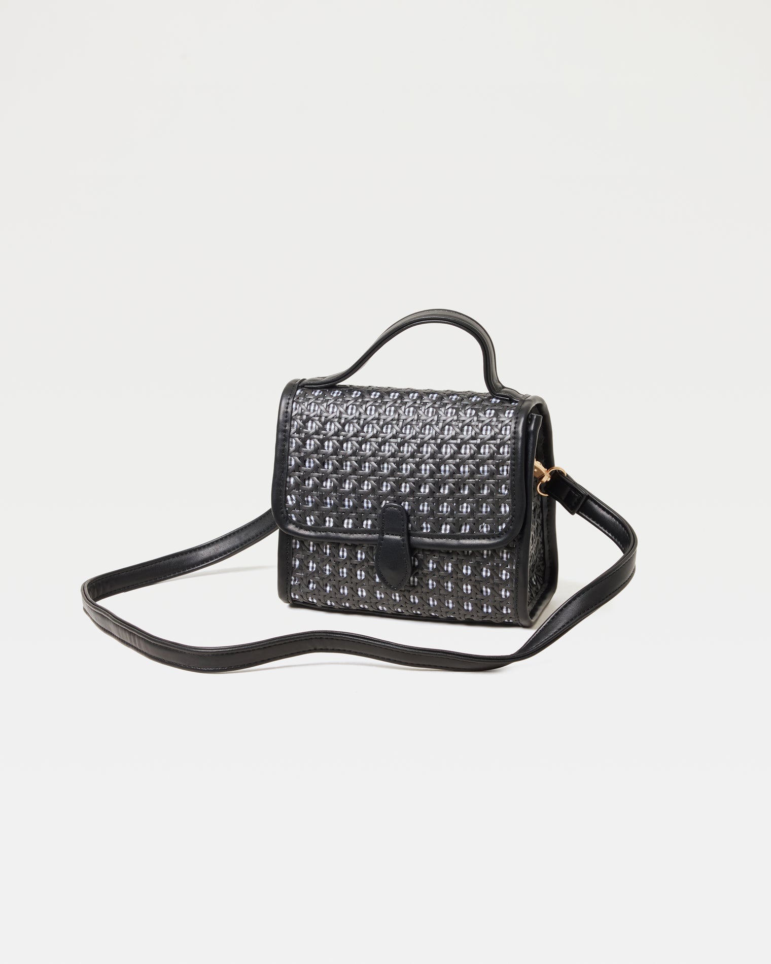 Off-model image of the Amelia Bag in black, a structured mini woven top-handle crossbody bag, with the crossbody strap extended.