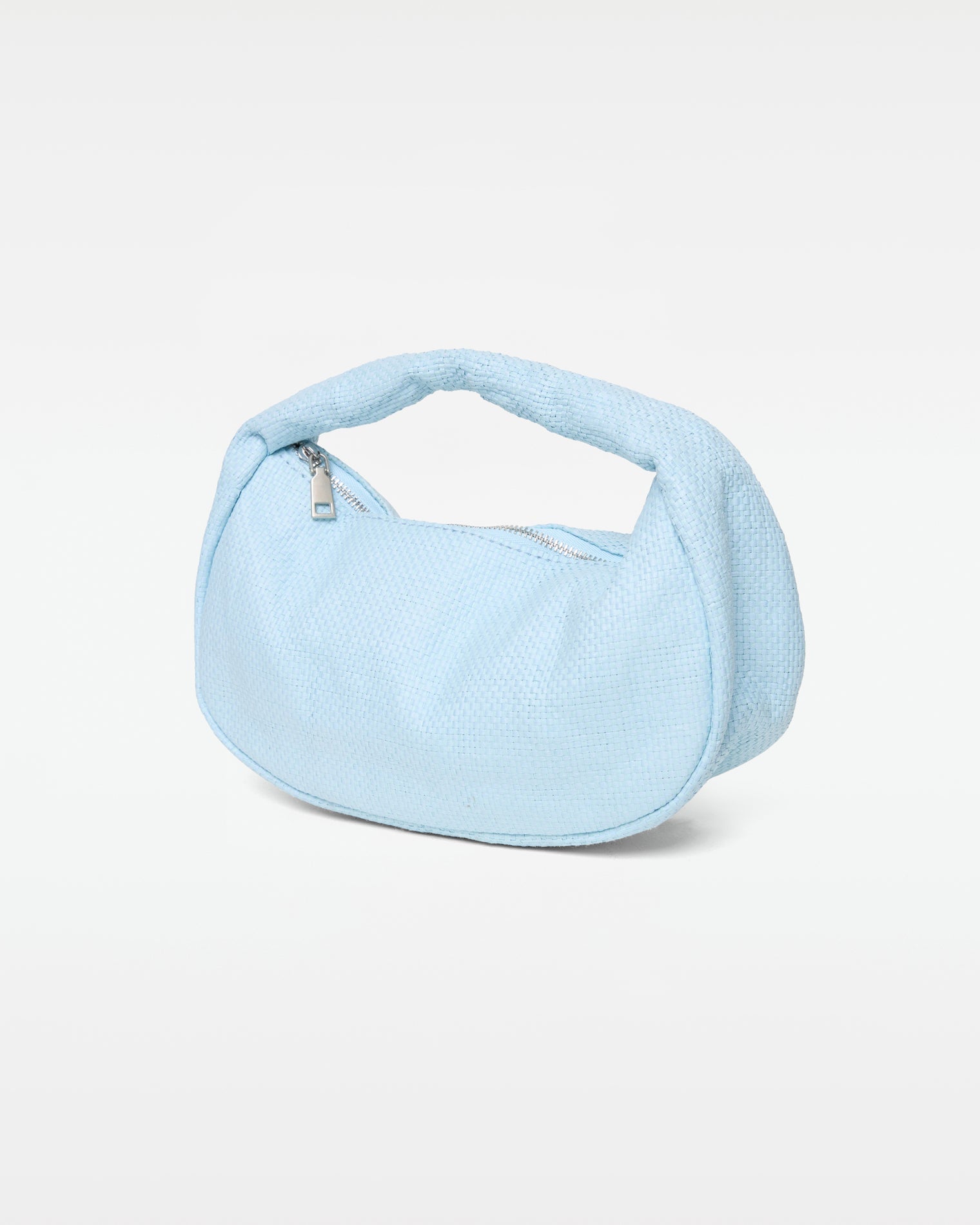 Angled view of the Mendoza Bag in sky blue showing the woven texture, silver zipper closure, and curved handle.