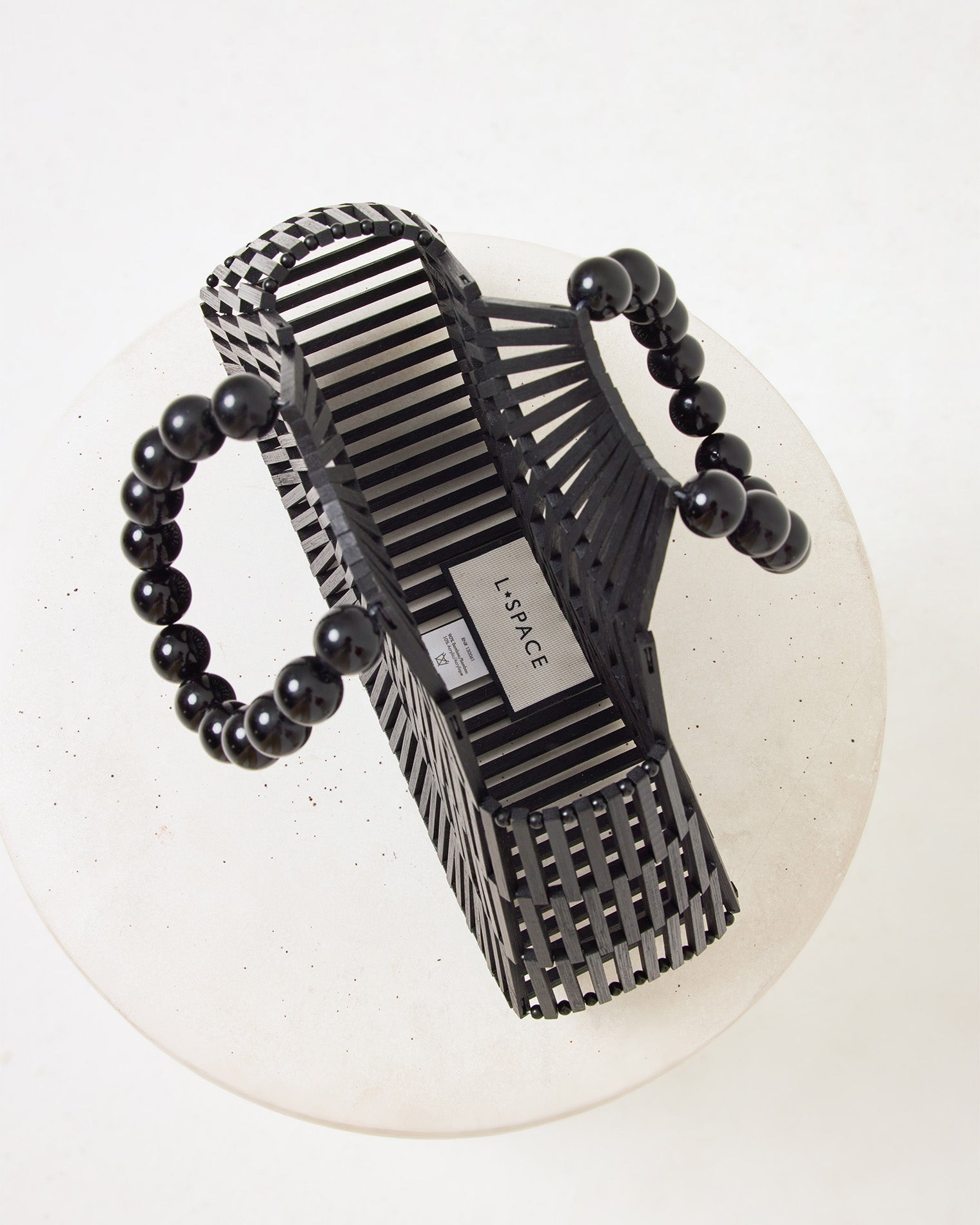 Top-down view of the Starlight Bag in black showing the interior with the LSPACE branding label and black beaded handles.
