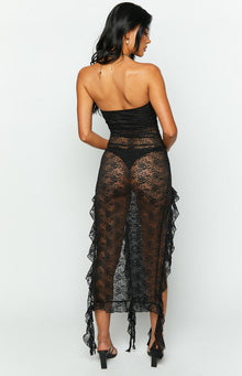 Rear view of a black sheer lace midi dress with a strapless bodice and cascading ruffled trim along the skirt
