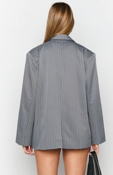 Rear view of an oversized grey pinstripe blazer with a structured collar