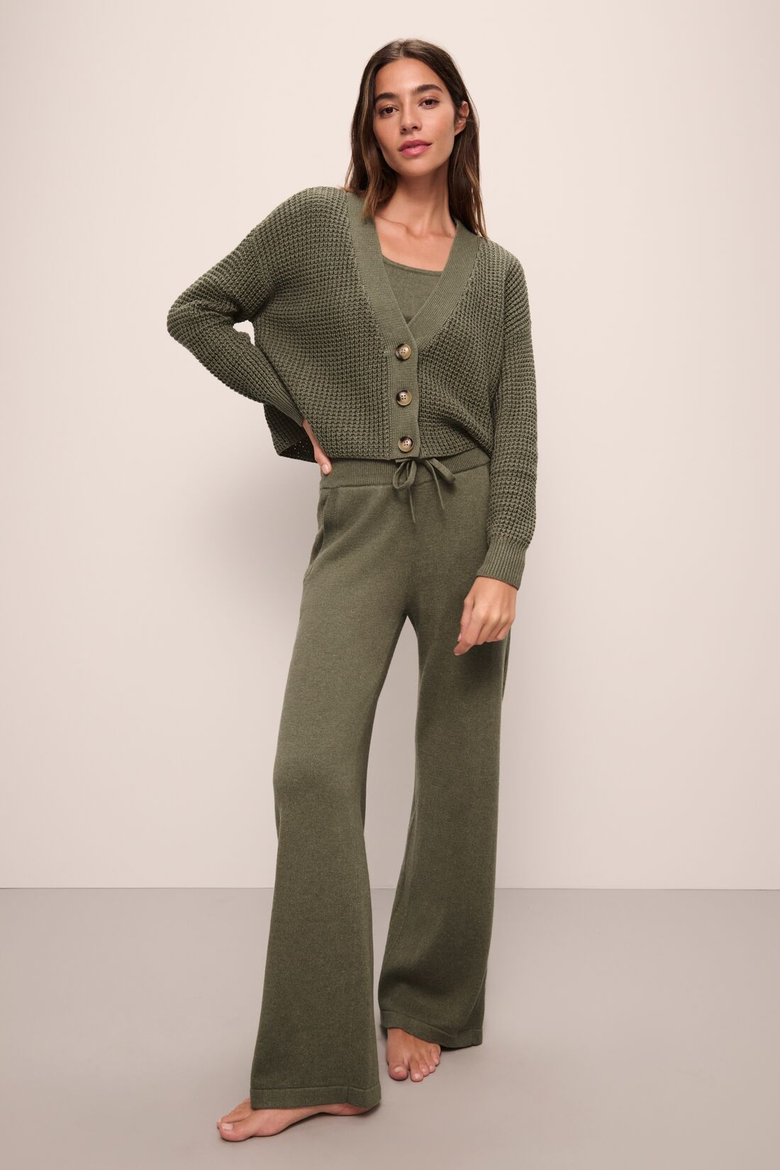 Model wears Recycled Sweater Pant in Moss.